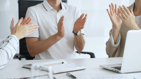 Business team applauding after achieving a goal during a productive meeting in a modern office environment, celebrating success and teamwork, close upの写真素材