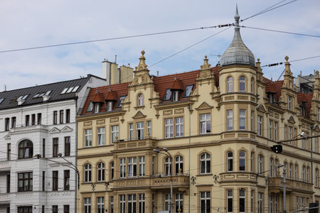 Historic European architecture featuring ornate facade with spires and red roof in cityscape, capturing classic design elements of 19th century urban buildings against clear sky backgroundの写真素材