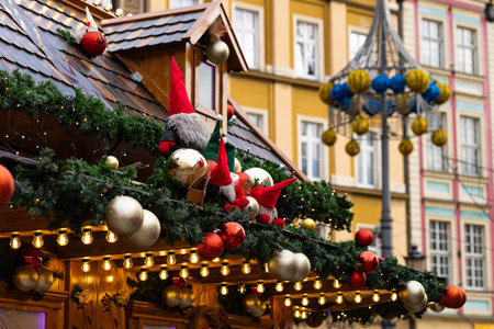 Festively decorated wooden house roof at the Wroclaw Christmas Market, adorned with fairy lights, Christmas ornaments and cheerful gnomes. Traditional holiday decorations and winter festivitiesの写真素材