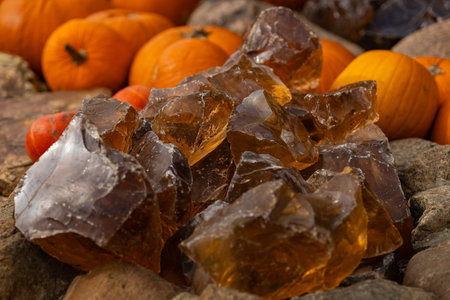 Natural amber like stones with pumpkins on rustic background used as seasonal decoration at autumn...