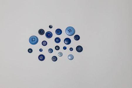 Collection of various blue buttons arranged artistically on a light background, showcasing different...