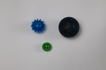 Set of colorful massage balls in different sizes placed on white background. Muscle recovery,...