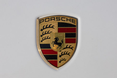 Wroclaw, Poland - June 21, 2025: Close up of Porsche crest logo on white car hood, showcasing iconic...