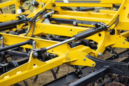 Close up of modern agricultural trailer frame with hydraulic cylinders and metal components on...