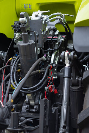 Close up of industrial hydraulic system with metal cylinders, hoses and control valves inside modern...