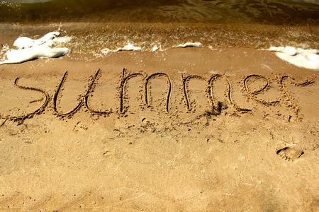 Inscription summer on the sand by the sea with waves.の写真素材