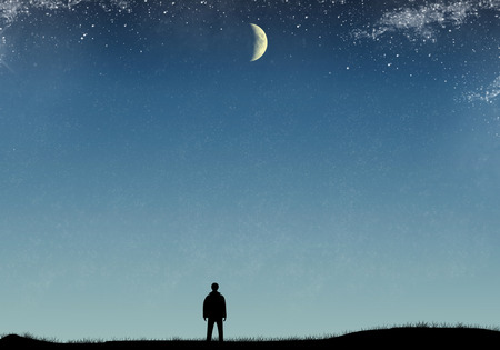 Silhouette of a man on the field with grass, starry sky and moon.の写真素材