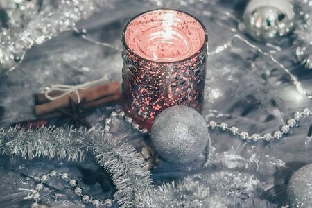 Shiny candlestick with a burning candle on a silver background with festive decorations. Flat lay cardの写真素材
