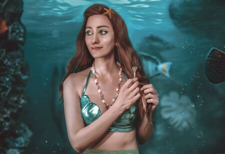 A beautiful mermaid in the bottom of the sea on a underwater background closeupの写真素材