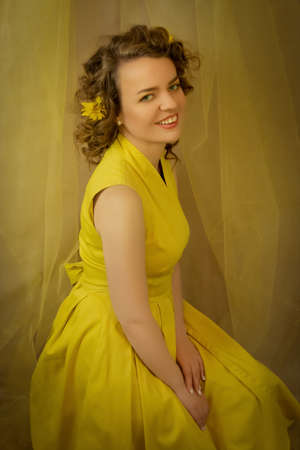 Bright sunshine lady in yellow dress with yellow flowers closeup.Art processing.の写真素材