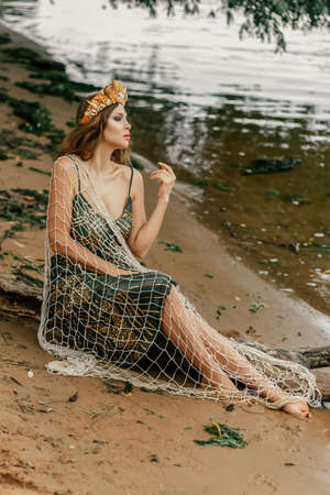 Young beautiful mermaid woman close up is standing in the seawater. Cosplay mermaidの写真素材