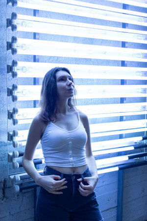 Young pretty girl stand near the lighting illumination closeup.の写真素材