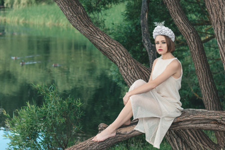 Young beautiful mermaid in seashells crown is sitting on the water background.Mermaid cosplayの写真素材