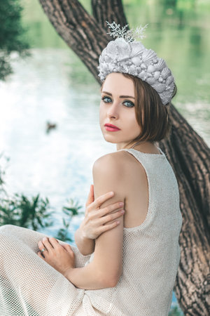 Young beautiful mermaid in seashells crown is sitting on the water background.Mermaid cosplayの写真素材