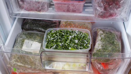 Open freezer with frozen vegetables. Frozen asparagus, dill, and zucchini. Food storage. Frozen food. Stocks of products for the quarantine period.の写真素材