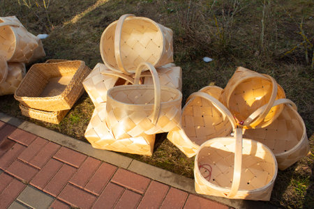 Many different wicker baskets made of natural material. Wicker baskets on the paving stones of a street market.の写真素材