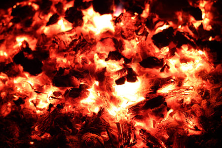 Background from a fire, firewoods and decaying red coals
