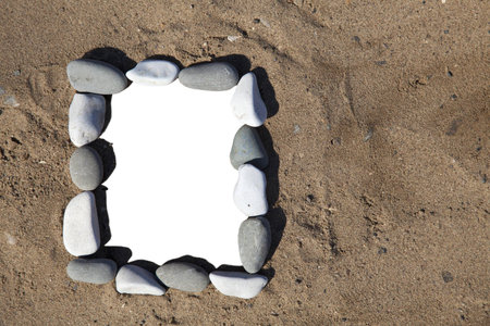photo frame of stones on  sand