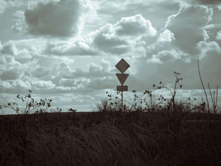 empty road signs on the background of the clouds in shades of grayの写真素材