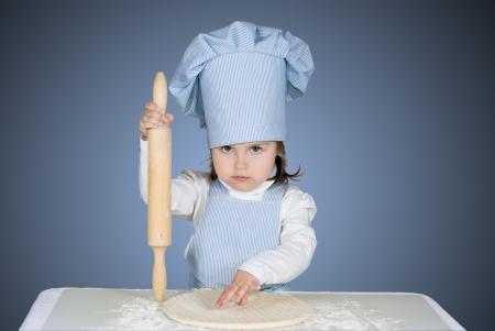 Beautiful little girl masrer chief cooking pizzaの写真素材