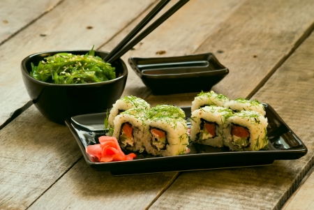 Sushi and chuka seaweed salad with soy sauce on wooden tableの写真素材