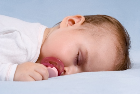 Close-up portrait of a beautiful sleeping baby on blue blanket  Use the photo to represent life, parenting or childhood の写真素材