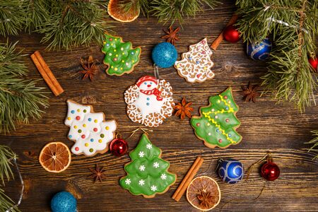 Christmas gingerbread cookies decorated with icing on wooden table, flatlay. Christmas and New Year traditions, winter holidays, homemade sweets, festive foodの写真素材