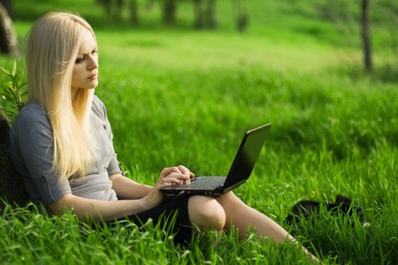 series. The beautiful business woman with the laptop has a rest in the fieldの写真素材