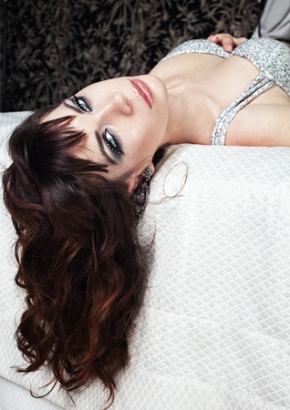 Series. A young girl in a silver dress resting in a hotelの写真素材