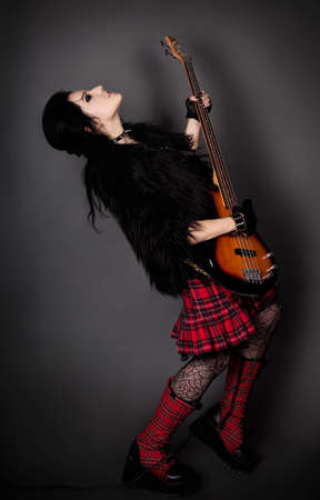 series. Fashion style photo of young rocked woman in studio  with guitarの写真素材