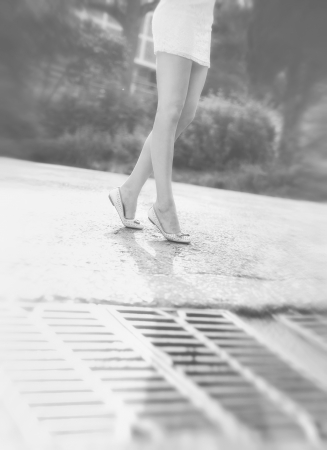 The beautiful blonde in a short white dress walks in the parkの写真素材