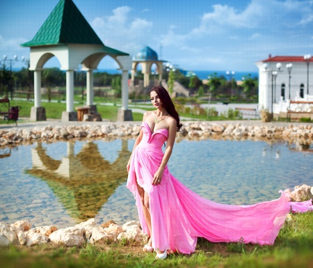 The beautiful harmonous girl in a long pink dress の写真素材