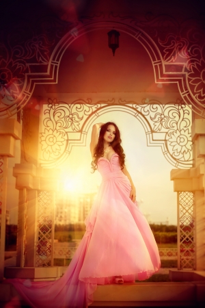 The beautiful harmonous girl in a long pink dress の写真素材
