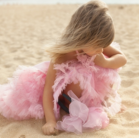Beautiful little girl in a pink dress walkingの写真素材
