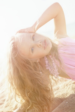 Beautiful little girl in a pink dress walkingの写真素材