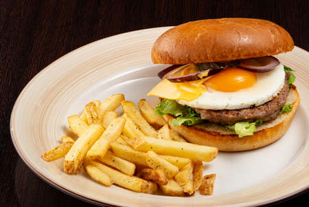 Burger with egg and friesの写真素材