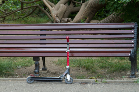 Scooter near the bench in the city Park.