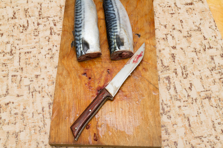 mackerel without head on a wooden Board on the kitchen tableの写真素材