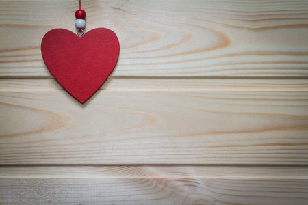 Wooden red heart suspended on a natural wood background.Valentine's day.の写真素材