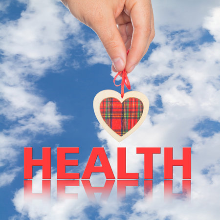 hand with  heart and  word health on the background.の写真素材