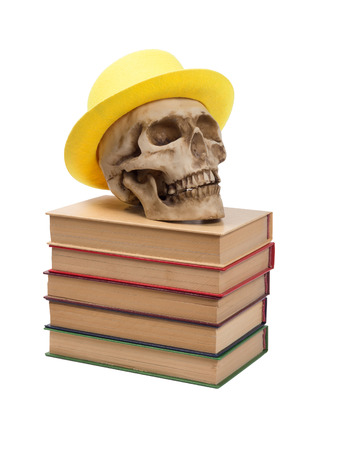 Skull in yellow hat on books isolated on white background.の写真素材