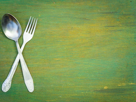 Fork and spoon on old wooden table. Vintage texture, background. Menu.の写真素材