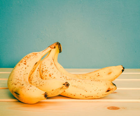 Bananas on a wooden table on a blue background.の写真素材