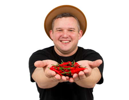 Young fat man with chili in his hands. Isolated on white background.focus on peppersの写真素材