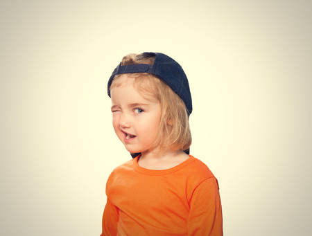 Little Funny girl in baseball cap and orange blouse.の写真素材