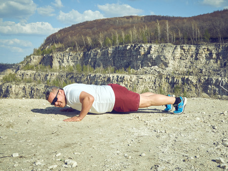 man doing pushups outdoors in nature. An active holiday. Fitness, sports. Lifestyle.の写真素材