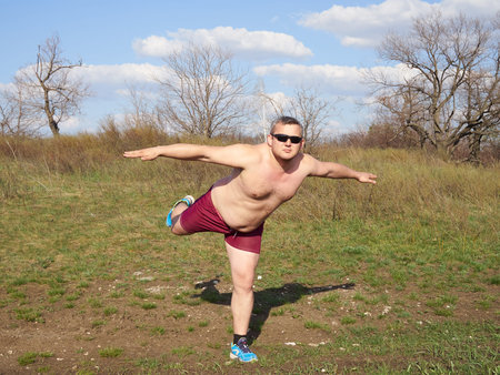Fat man doing yoga outdoors in nature.の写真素材