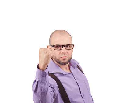Angry businessman threaten with a fist . A bald man with a beard in a shirt with suspenders.