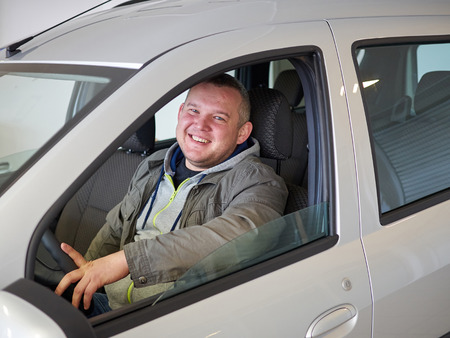 Young fat man behind wheel. Smiling Caucasian manの写真素材