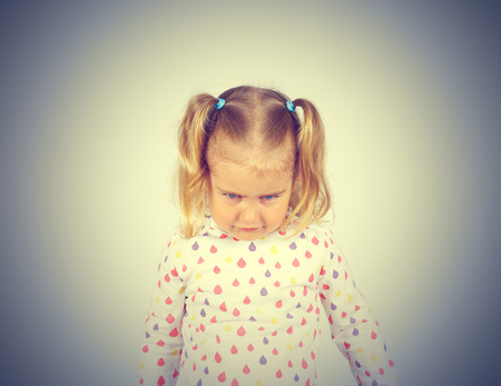Little girl looking down hurt. Emotions.の写真素材